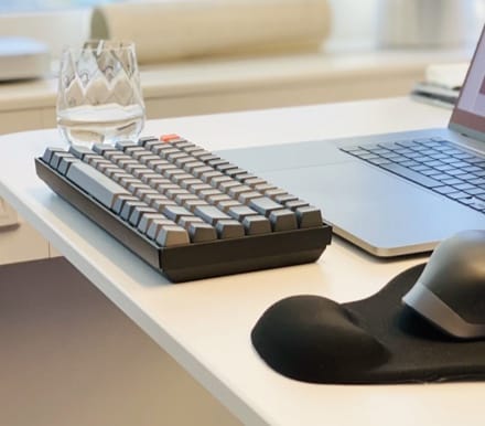 keyboard laying next to a phone on table